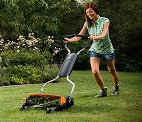 Young woman using a reel mower