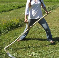 woman cutting grass with scythe